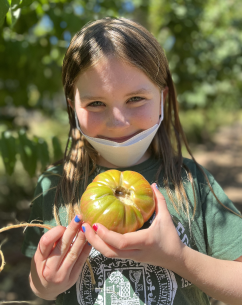 A girl kindly smiling and holding our produce for you